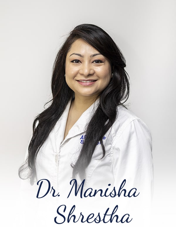 Dr. Manisha smiling in her lab coat
