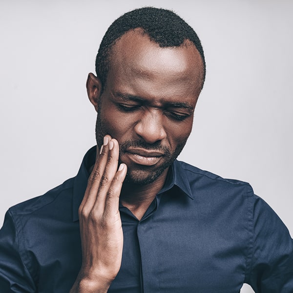 A man holding his TMJ in pain